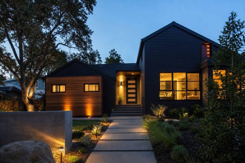 Modern house exterior at dusk with warm lighting and cedar accents