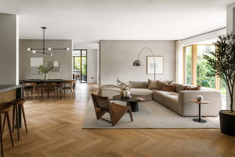 Open-concept living and dining room with herringbone oak floors